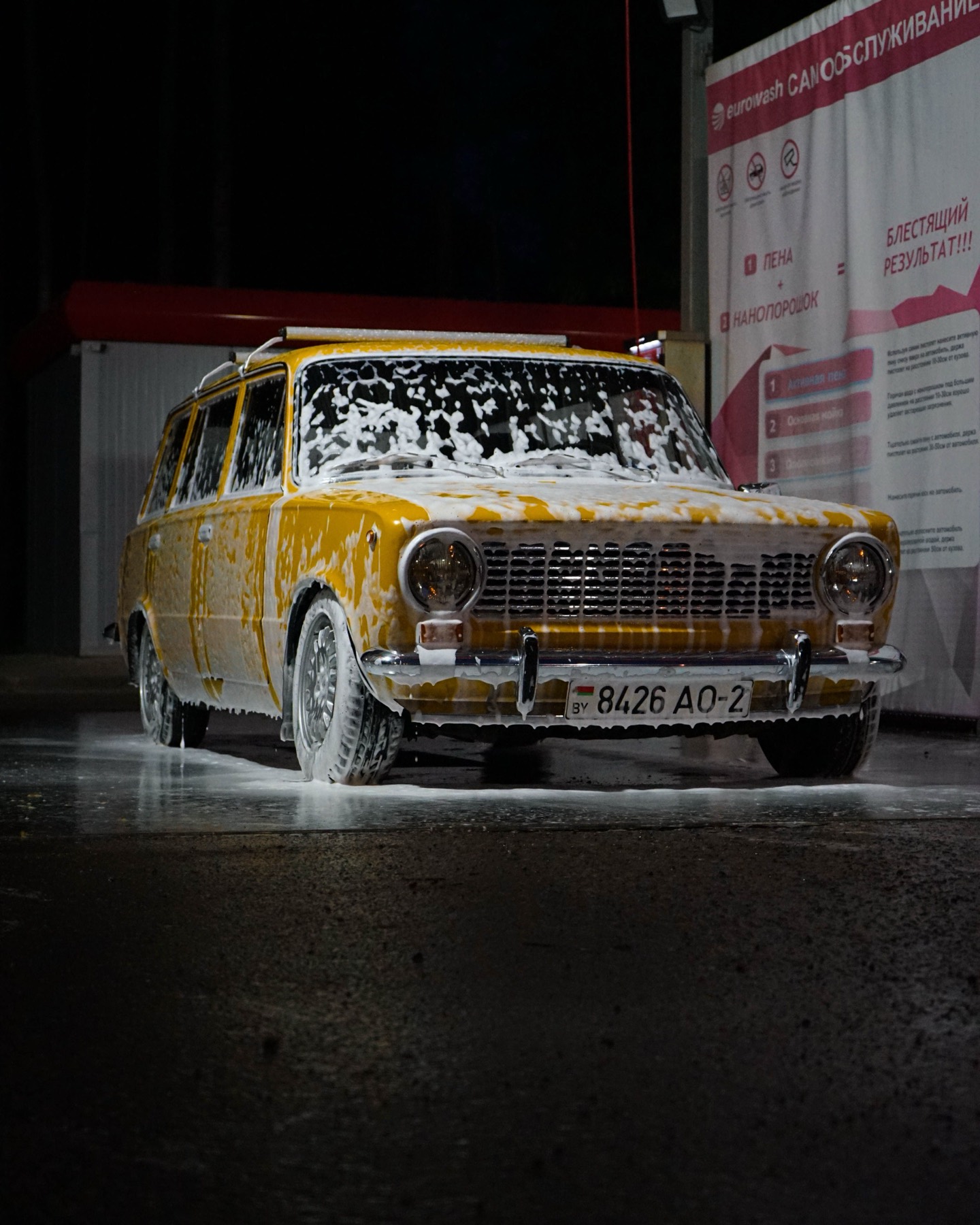 Foamed car under the lights at the wash bay